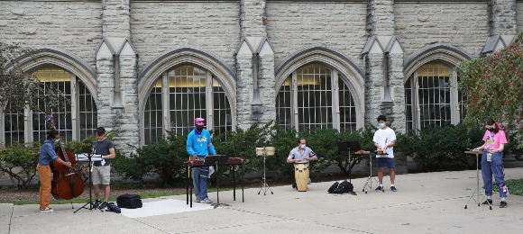 Students performing outdoors in front of Talbot College