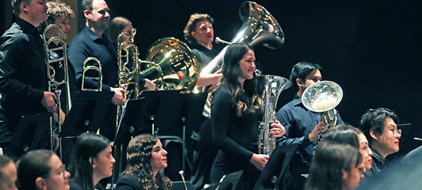 Wind Ensemble students on stage looking forward with pride