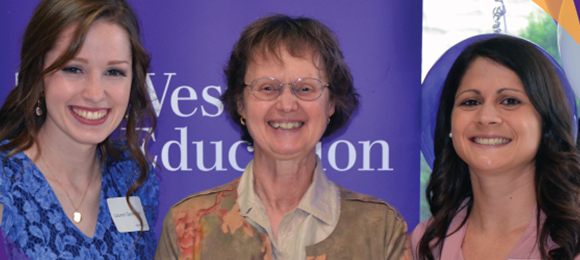 Photo of two students and an award presenter.