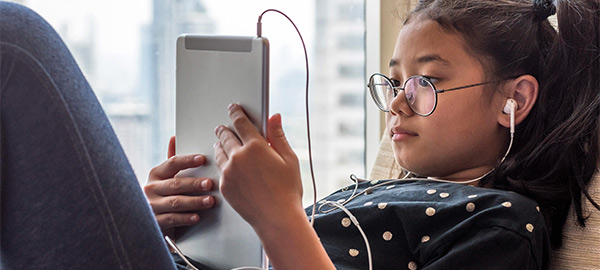 A child looking at an iPad while laying down.