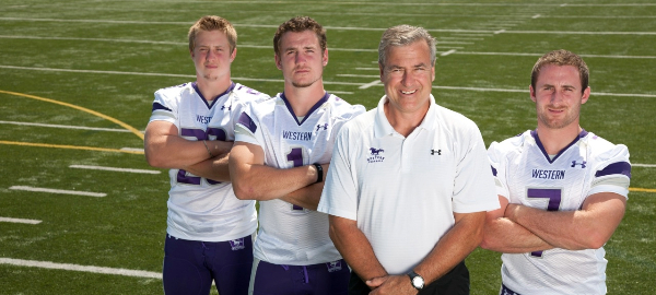 Mustangs Football Team Head Coach and Education alum Greg Marshall (second from right), stands alongside his sons (from left to right) Tom, Brian and Donnie.
