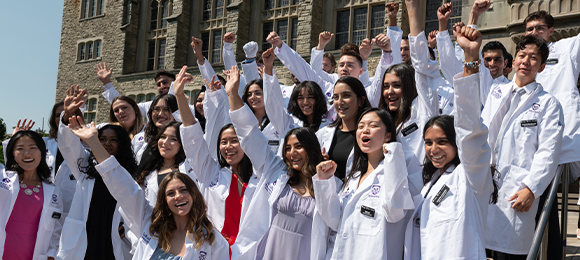 Medical students cheering with white medical lab coats on